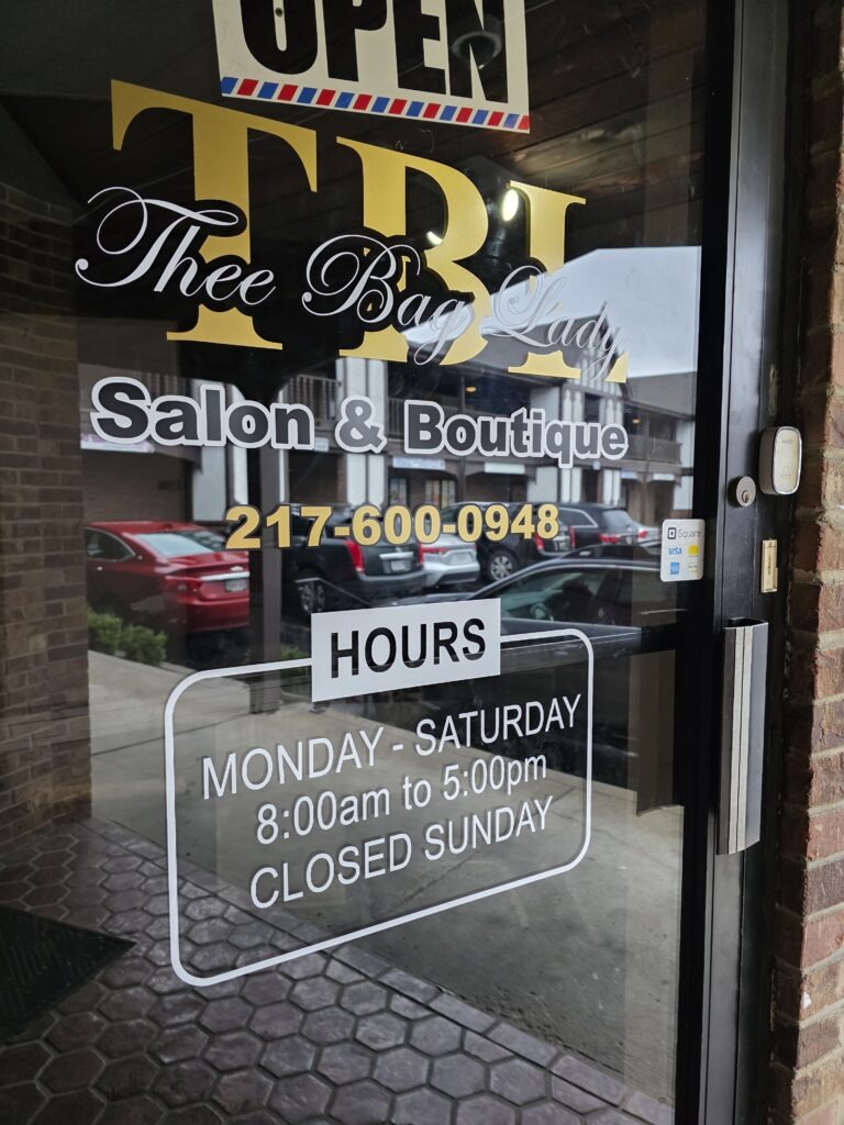 Signage of "Thee Bag Lady Salon & Boutique," displaying "OPEN" and business hours: Monday to Saturday