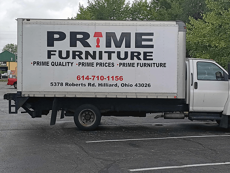 A delivery truck for Prime Furniture, featuring bold text advertising "Prime Quality, Prime Prices" and contact information