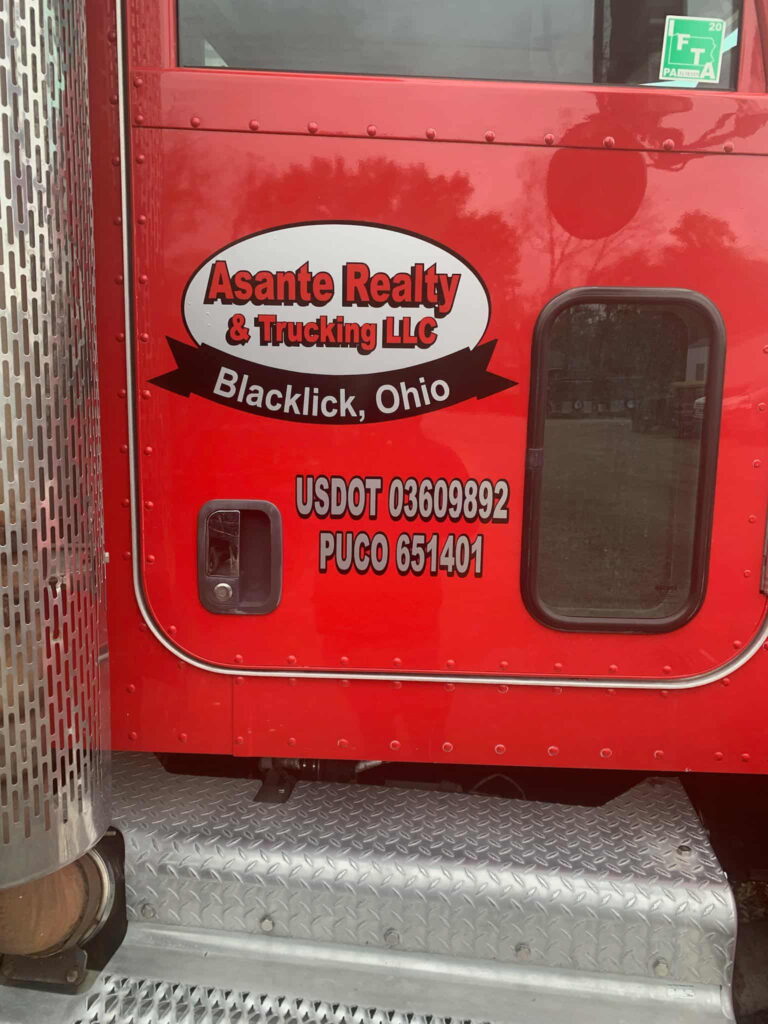 Logo of Asante Realty & Trucking LLC on the side of a red truck